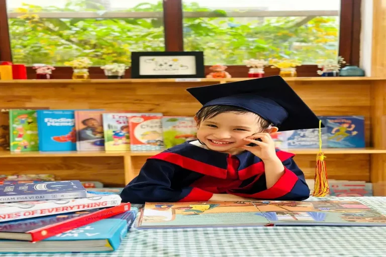 Niño sonriendo con su uniforme de graduado en educación infantil
